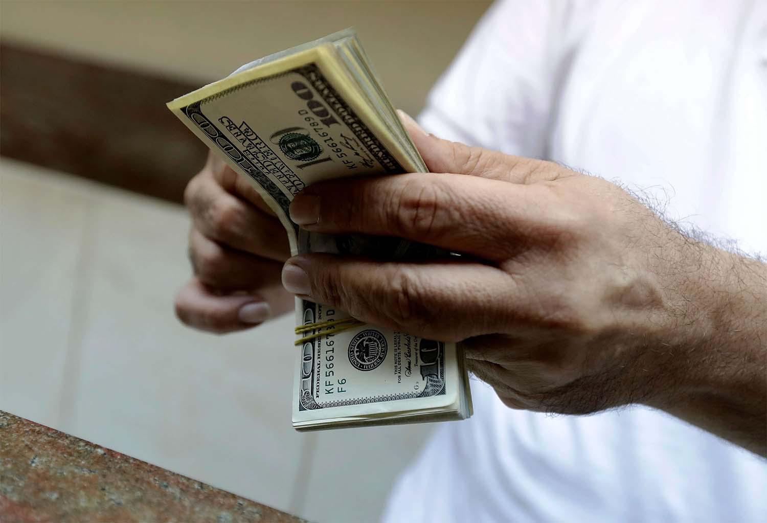 A teller counts US dollars at a currency exchange company in the Lebanese capital Beirut 