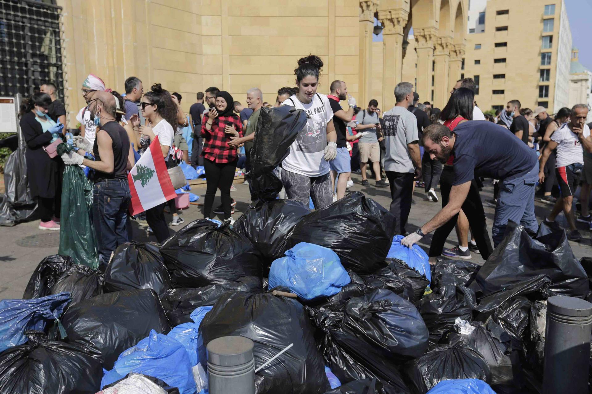 On the square, female volunteers scoop up piles of used half lemons -- some with rind curling off them -- and burnt trash.