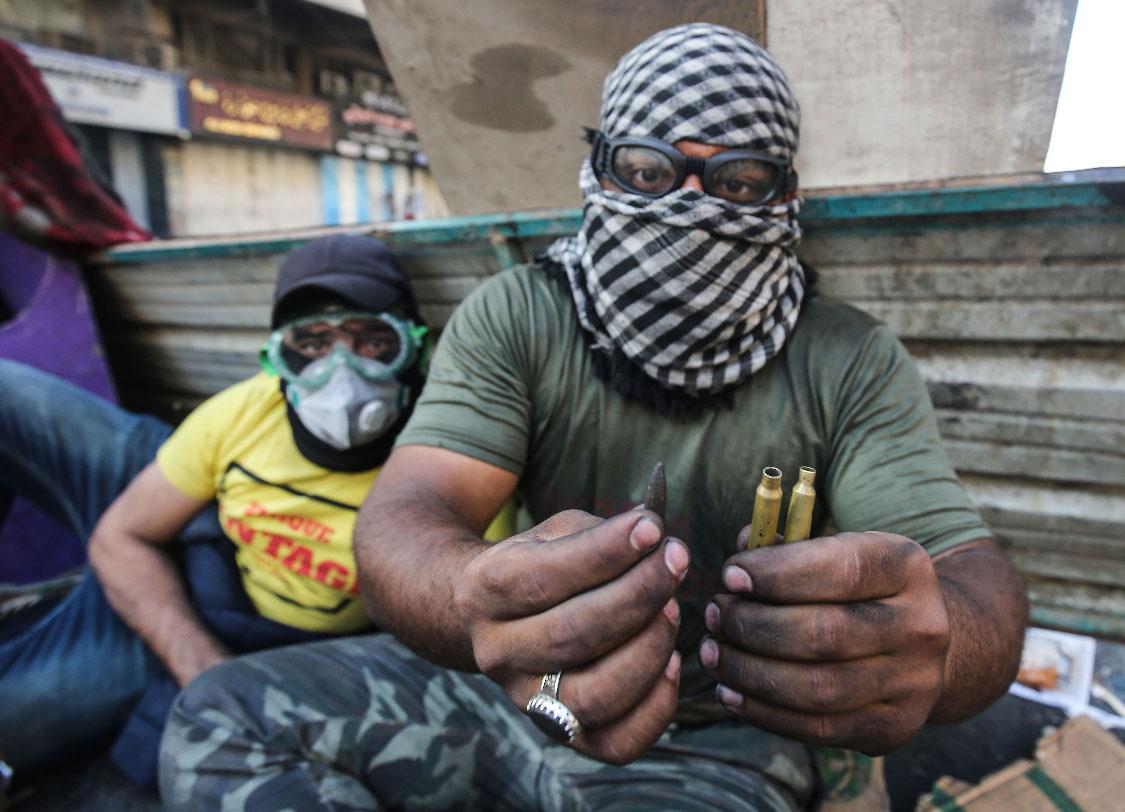 An Iraqi protester shows bullets amid clashes with security forces at Baghdad's Khallani square