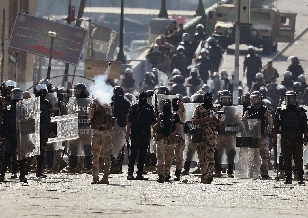 Iraqi riot police fire tear gas to disperse anti-government protesters gathering on the al- Shuhada (Martyrs) bridge