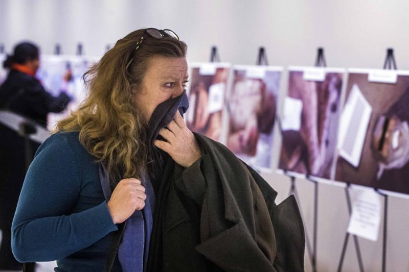 A woman reacts as she looks at a gruesome collection of images of dead bodies taken by a Syrian photographer, who has been identified by the code name "Caesar", at the United Nations Headquarters in New York.