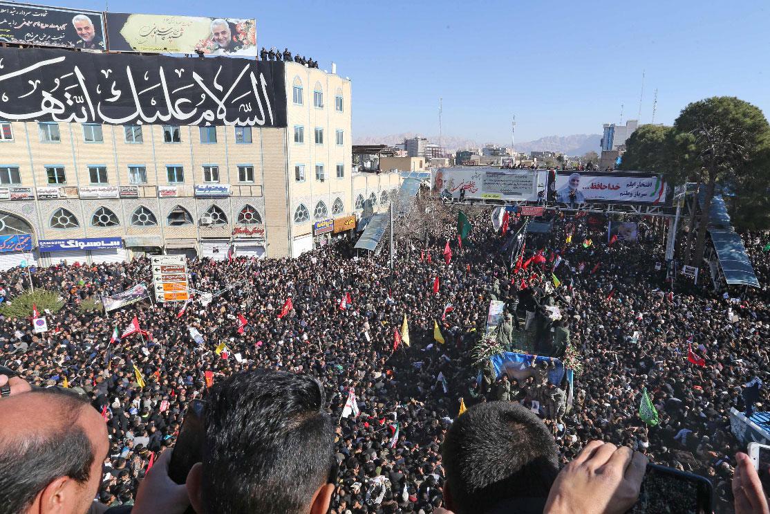 Iranian mourners gather around a vehicle carrying the coffin of slain top general Qassem Soleimani during the final stage of funeral processions, in his hometown Kerman