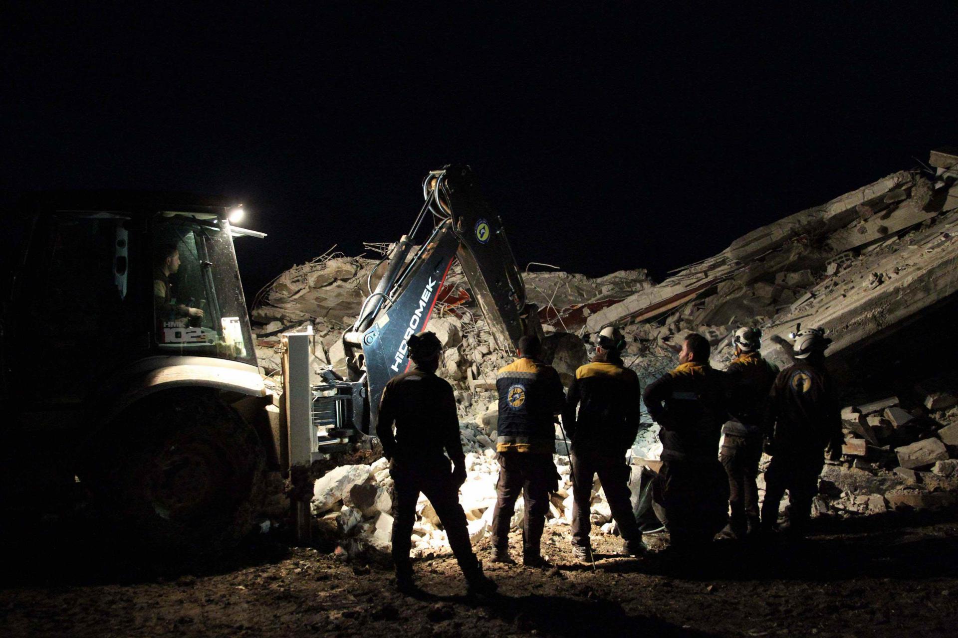 Members of the Syrian Civil Defence, also known as the White Helmets, search for survivors following an air-strike on the flashpoint town of Maaret al-Numan