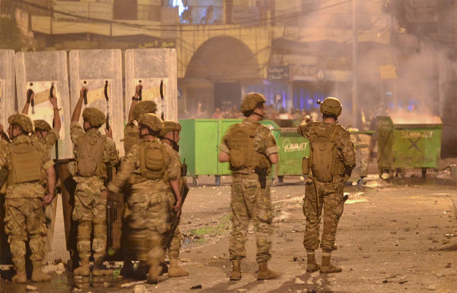 Lebanese soldiers with riot gear deploy during clashes with anti-government protesters in the northern port city of Tripoli