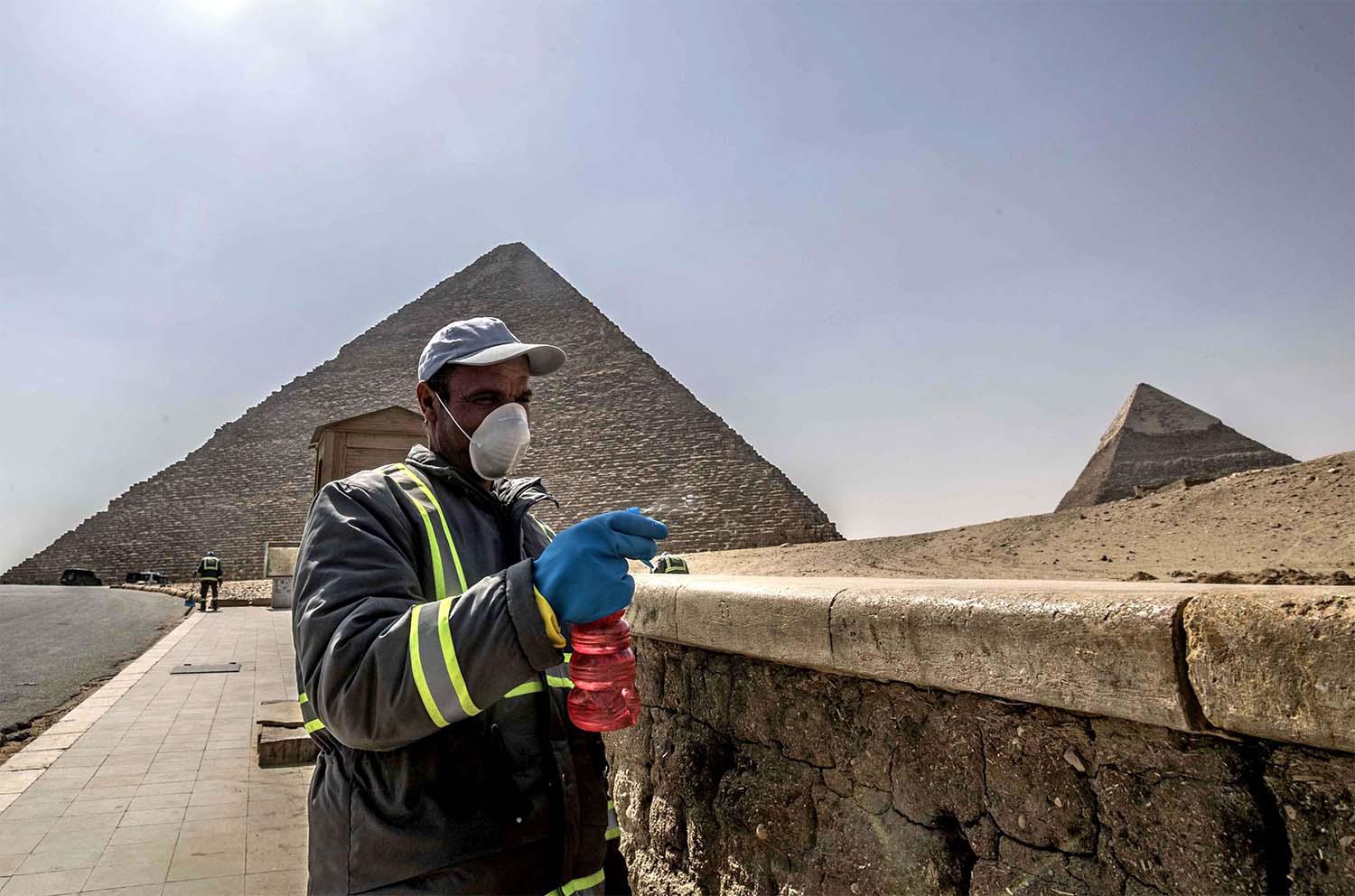 Egyptian municipality workers disinfect the Giza pyramids necropolis on the southwestern outskirts of Cairo