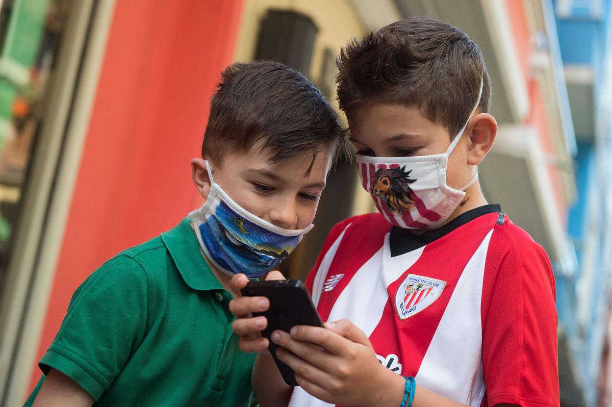 طفلان اسبانيان يرتديان كمامتين للوقاية من كورونا
