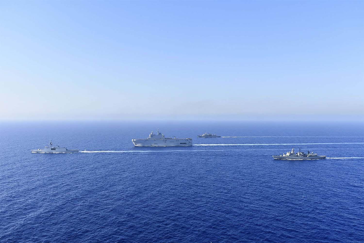 French Tonnerre helicopter carrier, center, and French Lafayette frigate, left, are escorted by Greek and French military vessels 