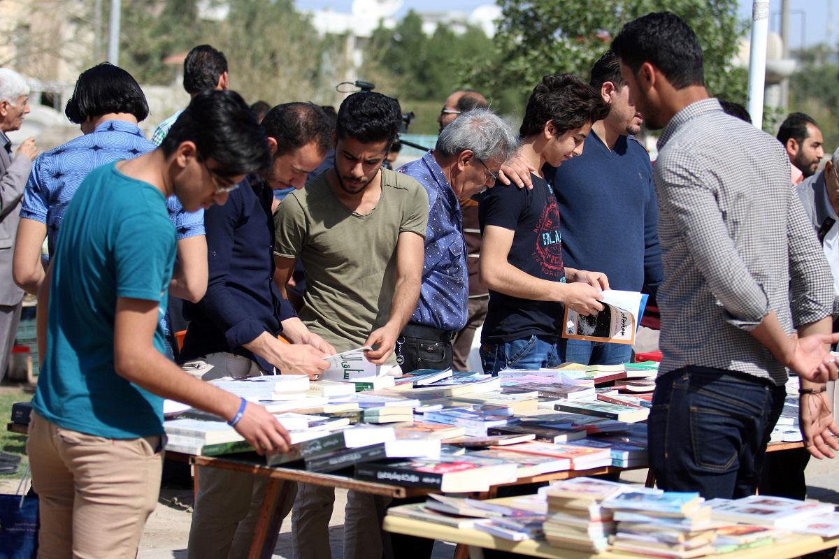 عراقيون يطالعون كتبا في شارع الفراهيدي بالبصرة