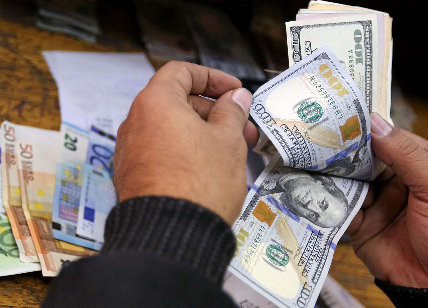 A man counts US dollars and Euros at a money exchange office in central Cairo