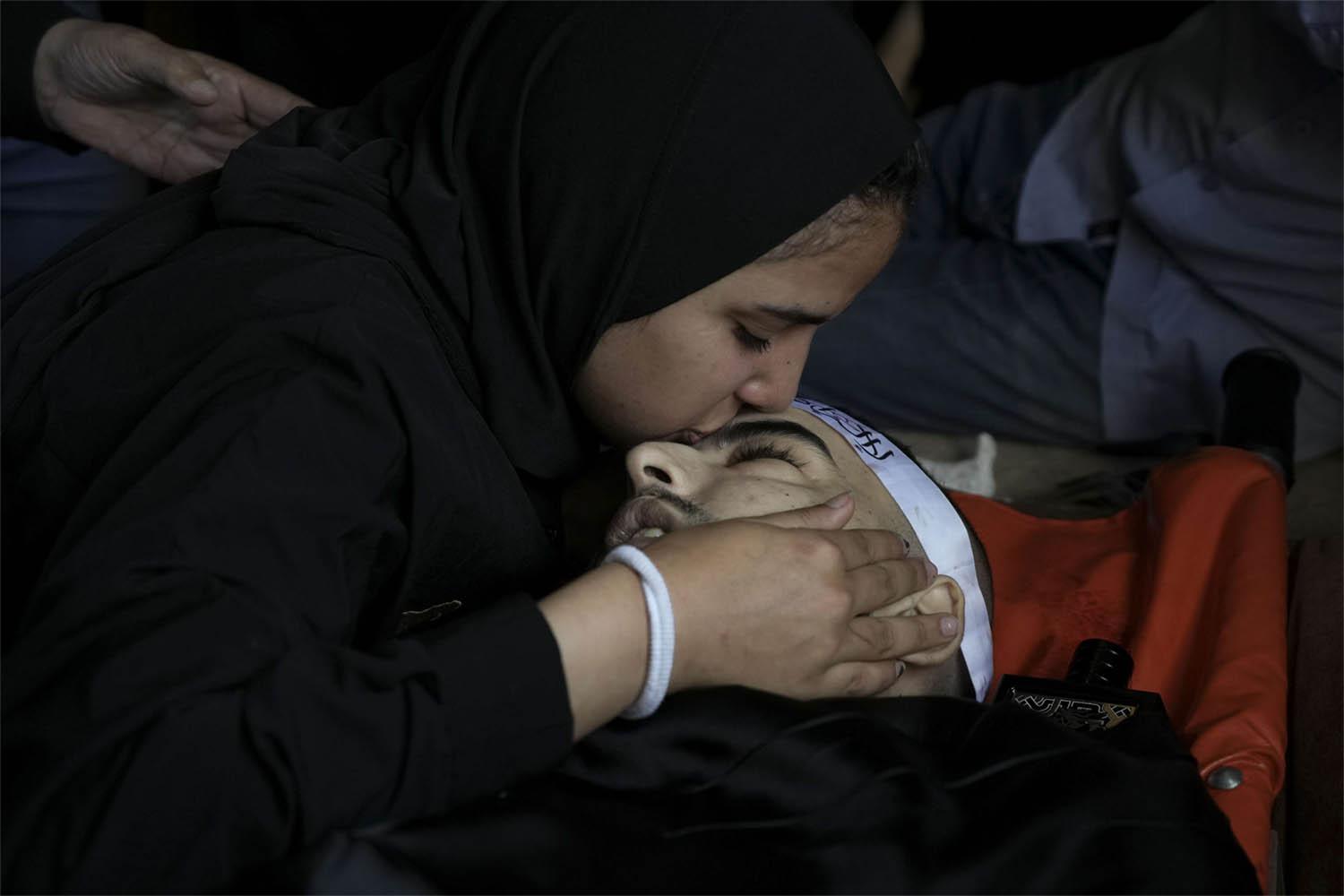 A mourner kisses the body of Palestinian Bara Lahlouh, 24, during his funeral at his family home in Jenin