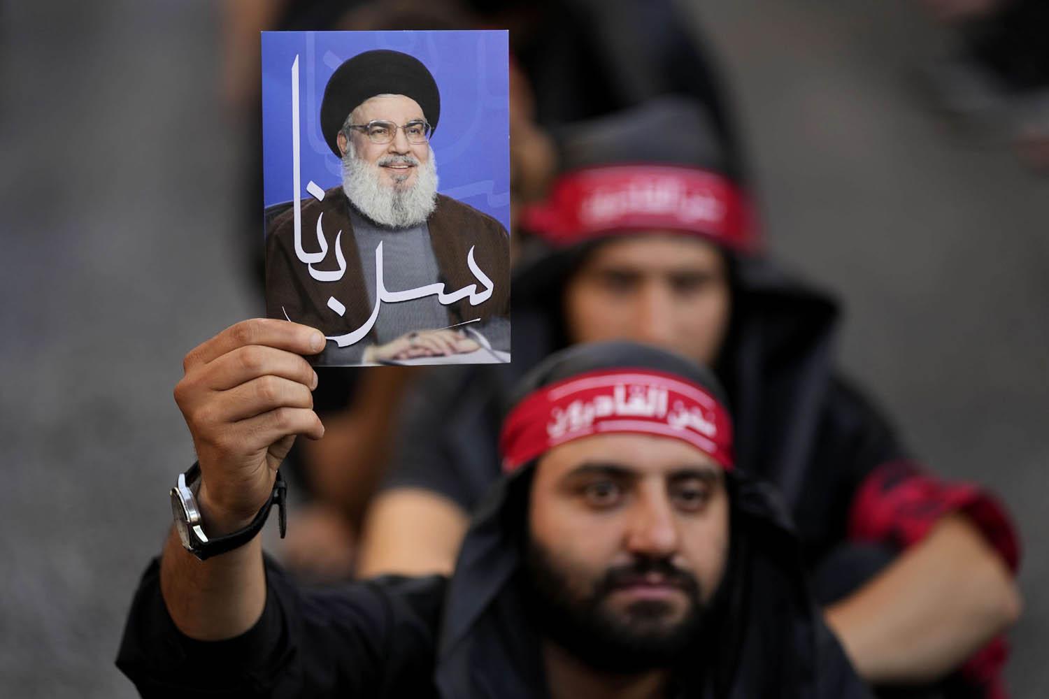 ناشط في حزب الله يرفع صورة لحسن نصرالله في احتفال بعاشوراء