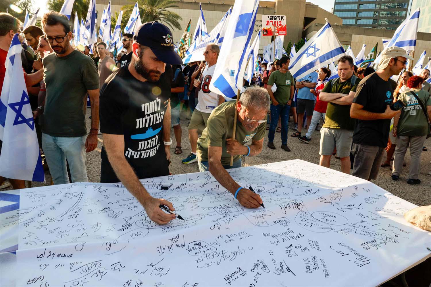Israeli military reservists sign a declaration announcing the suspension of their voluntary reserve duty