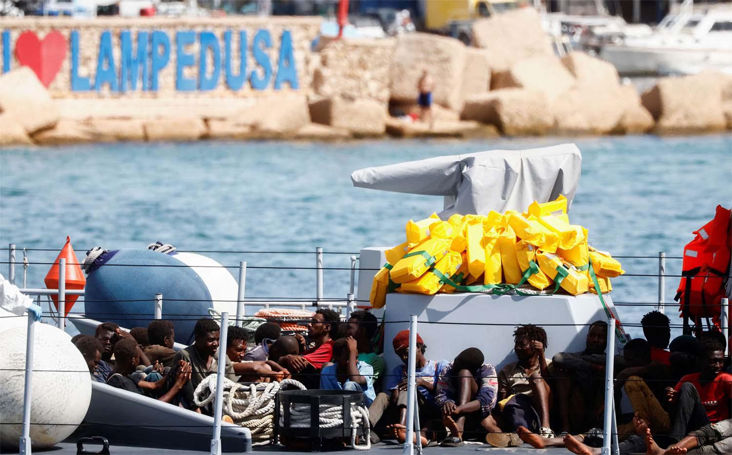 Migrants arrive on an Italian Coast Guard vessel after being rescued at sea, on the Sicilian island of Lampedusa