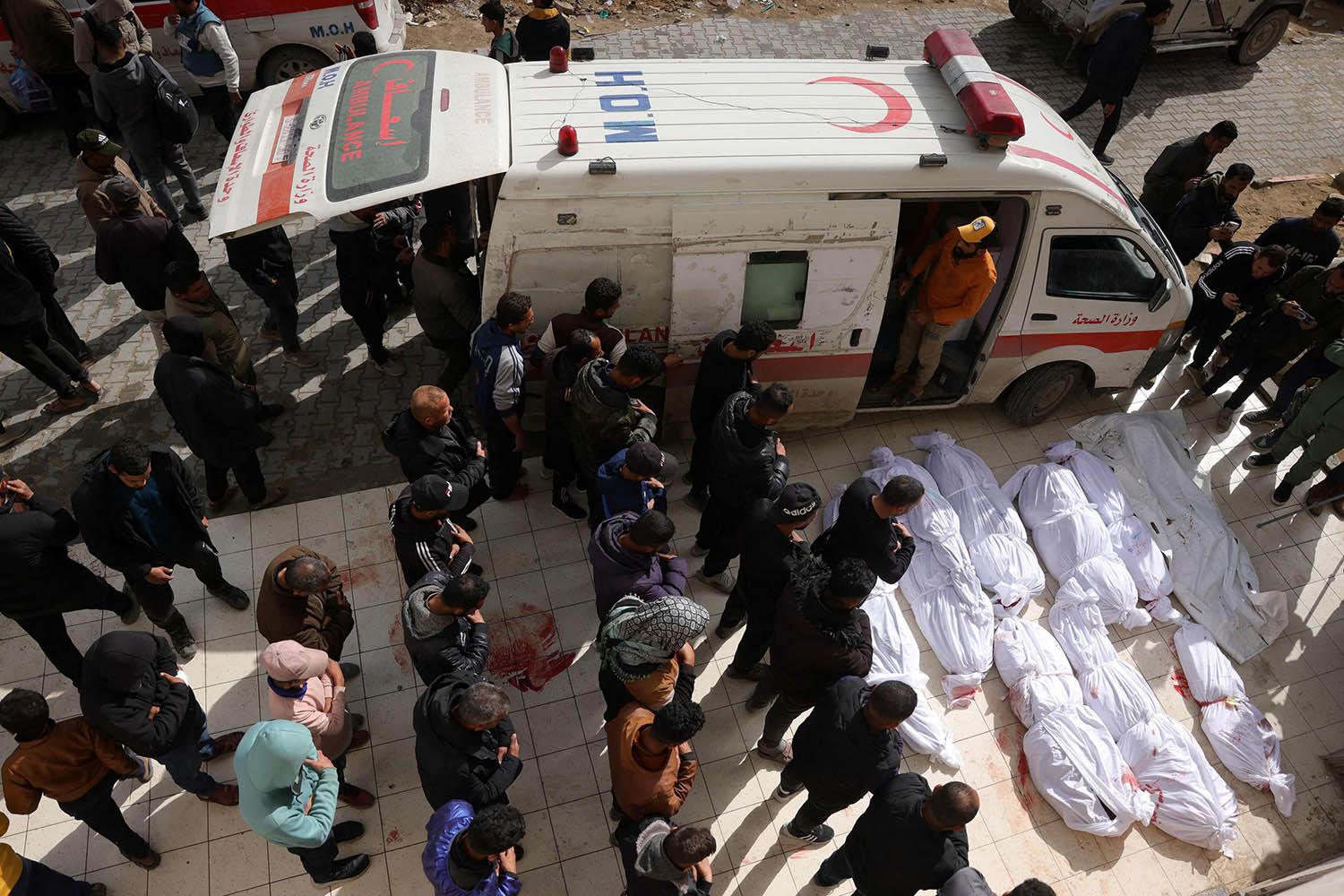 Palestinians recite a prayer over the bodies of victims of Israeli overnight airstrikes in the northern Gaza Strip