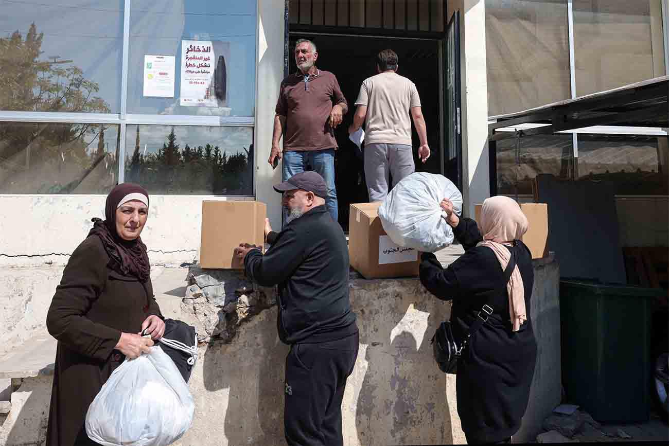 People receive food packages and other aid at the municipality center in Tyre